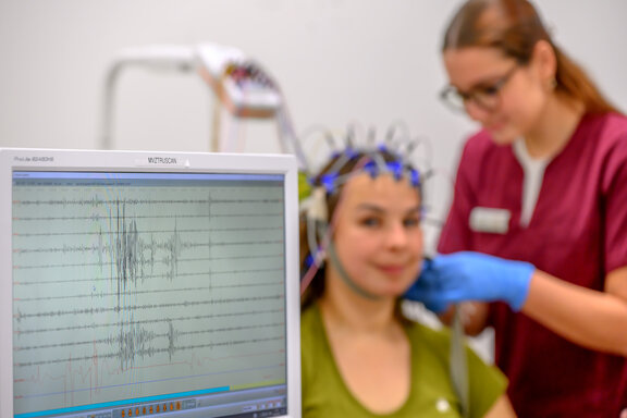 Eine Mitarbeiterin der Neurologie führt ein EEG bei einer Patientin durch 
